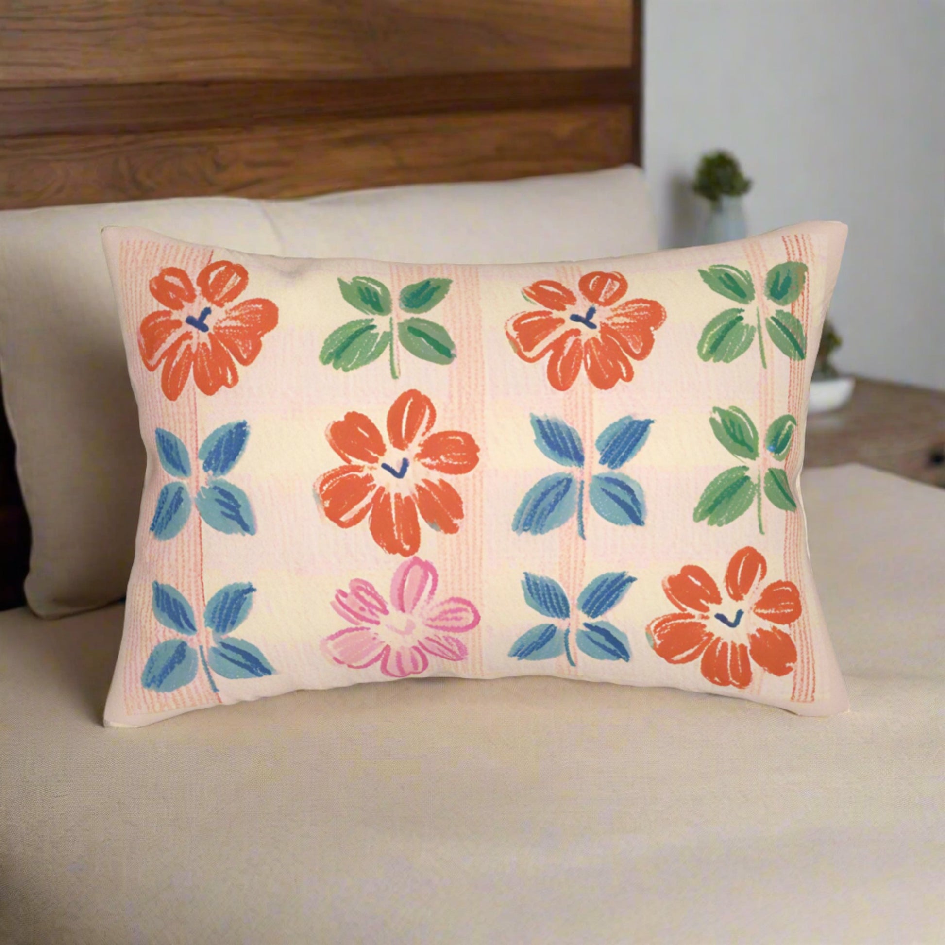 20"x14" Lumbar Throw Pillow featuring a Plaid  Flowers print in green, orange, grey-bleu and pink hues, set against a peach color backdrop. The back of the pillow is plain peach color. 